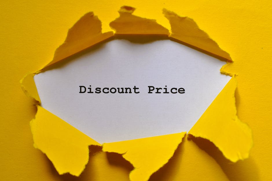 A close-up photograph of a torn yellow paper background with an irregular-shaped opening revealing a white sheet underneath that displays the black text 'Discount Price.' In the context of house removals and moving services, this image can symbolize special offers or cost savings related to furniture transport or packing and moving processes. The torn paper suggests a reveal or emphasis on affordability and transparent pricing, which aligns with the services provided by Man with Van Worcester Park, a company specialising in removals and home relocation. The setting appears to be indoors, with the torn edges of the yellow paper framing the message, indicating a focus on budget-friendly solutions for clients planning to move or requiring packaging for their household items.