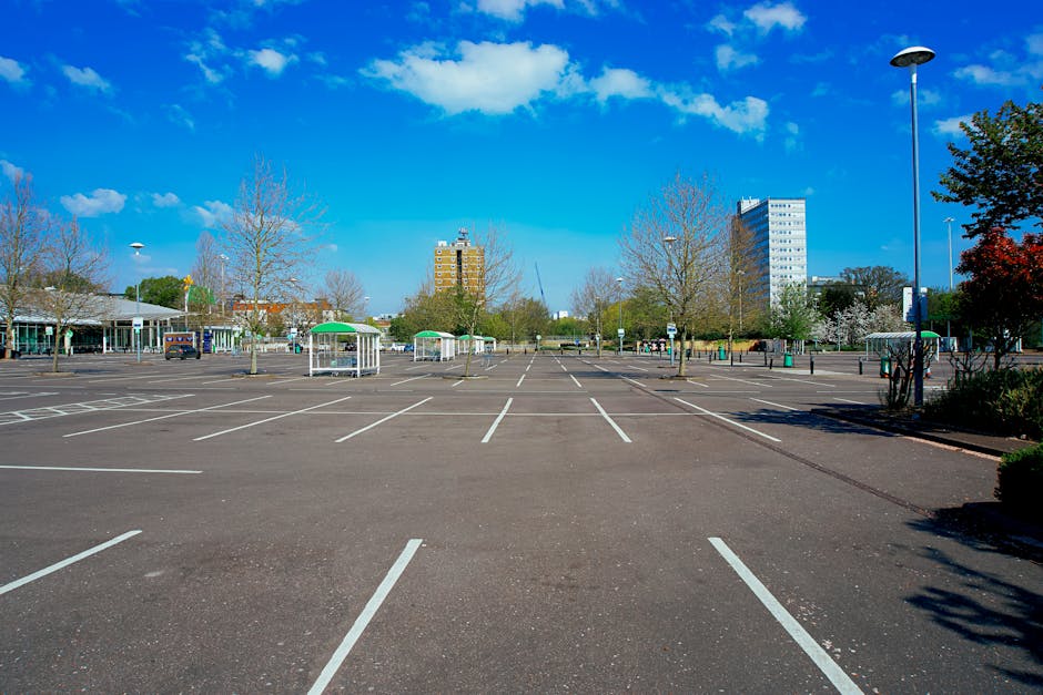 Close-up view of a blue disabled parking space surface with a white wheelchair symbol painted on it. The paint shows signs of cracking and weathering. In the background, there is a section of a pavement or driveway, indicating an accessible parking area typically used for home relocation or property transfers. The image is taken outdoors with natural lighting, highlighting the condition of the markings and surface. This visual is relevant for content about parking regulations and logistics involved in house removals and furniture transport, as handled by Man with Van Worcester Park.